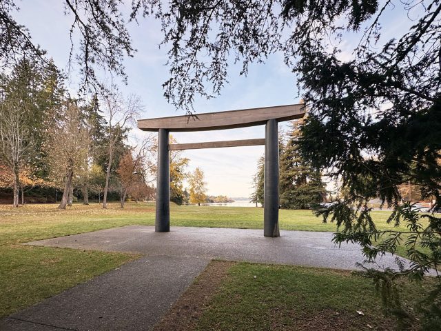 The new Torii gate at Seward Park is visible through trees on a clear blue November day.